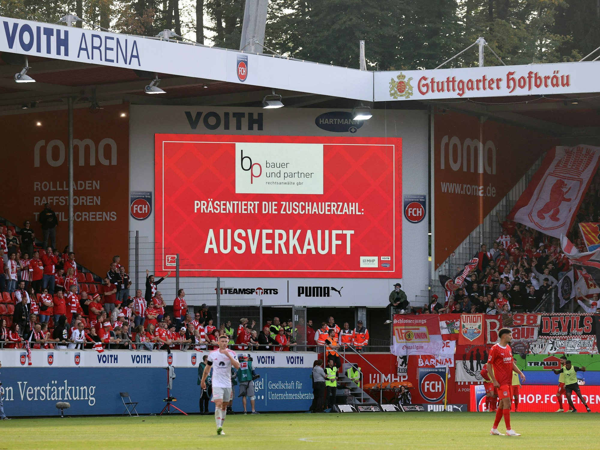 Die digitale Anzeige in der Voith Arena Heidenheim zeigt an, dass das Stadion ausverkauft ist. Darüber ist eine Werbetafel von Stuttgarter Hofbräu.