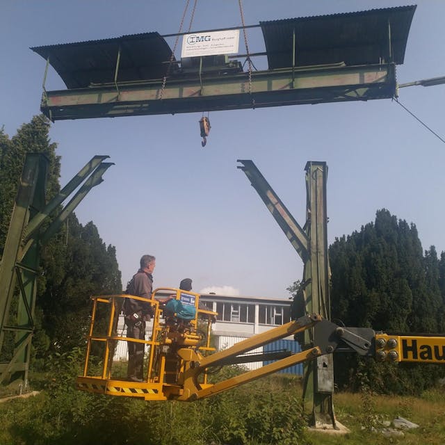 Arbeiter arbeiten von einem Hubsteiger aus am Wiederaufbau des alten Portalkrans vom Gelände des Morsbacher Bahnhofs. Der hat in Wissen an der Sieg einen neuen Platz gefunden.