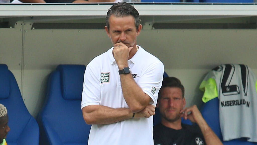 Dirk Schuster schaut als Kaiserslautern-Trainer skeptisch und nachdenklich auf das Spielfeld.