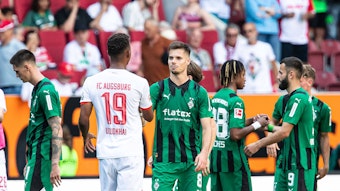 Die Borussia-Spieler klatschen nach dem Spiel in Augsburg miteinander ab.