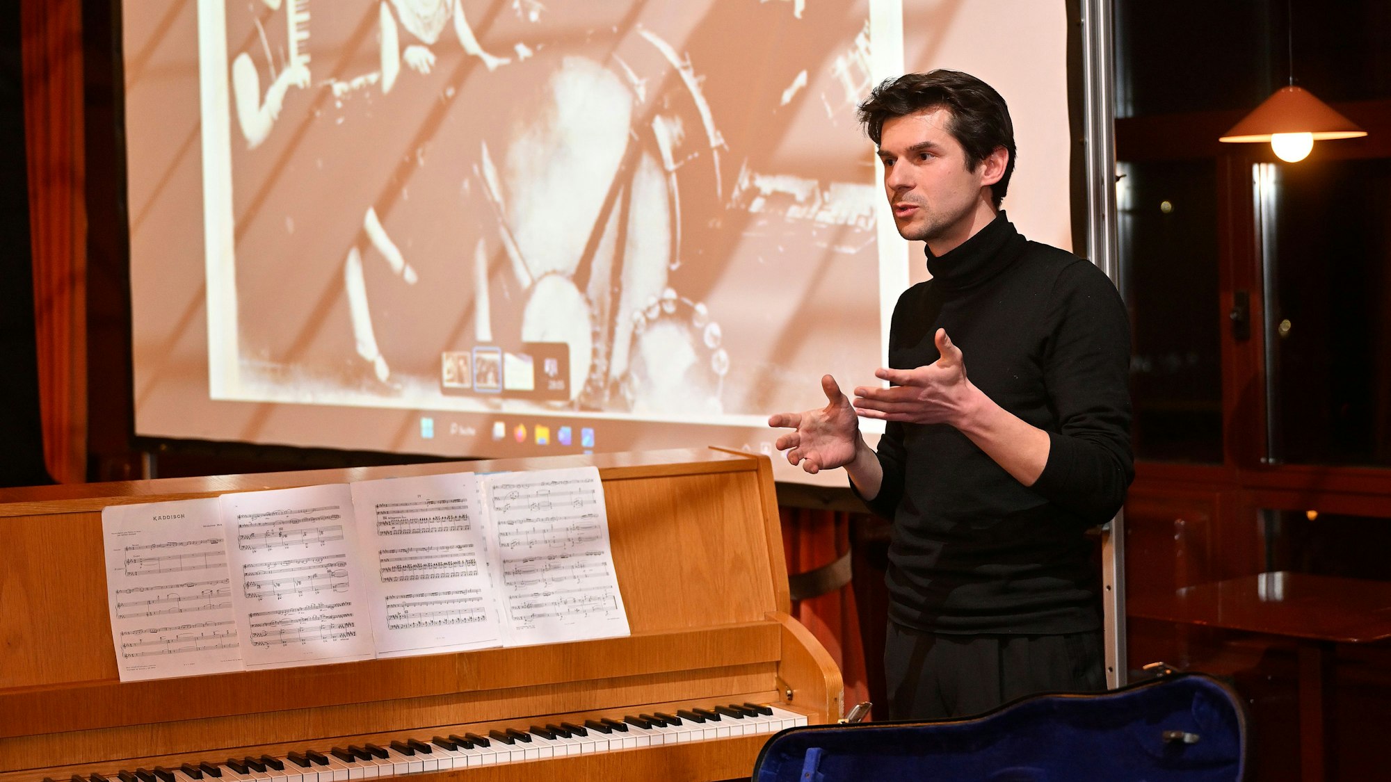 Roman Salyutov steht vor einem Klavier.