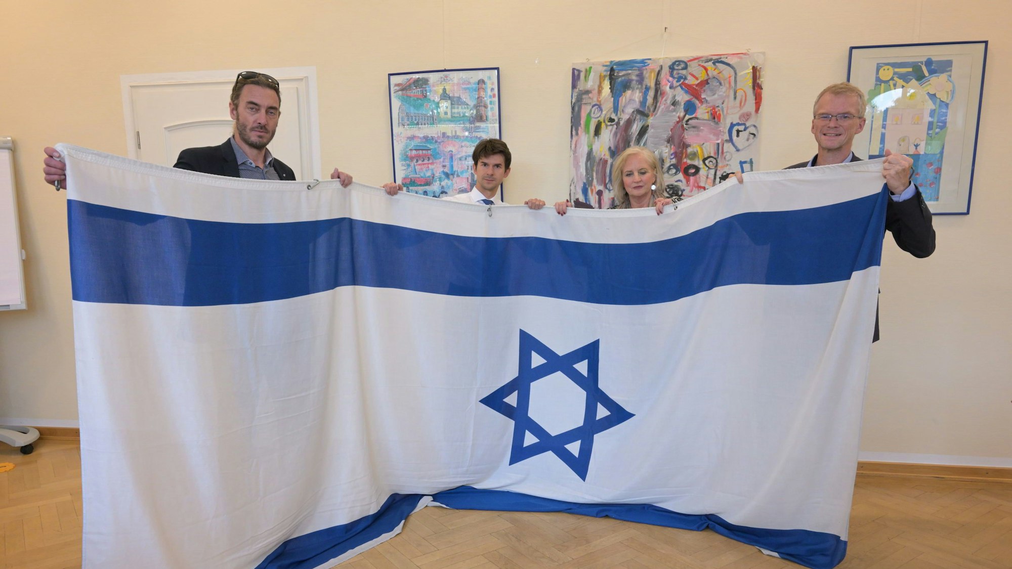 Axel Bolte, Roman Salyutov, Petra Hemming, Frank Stein stehen nebeneinander und halten eine Israel Flagge.