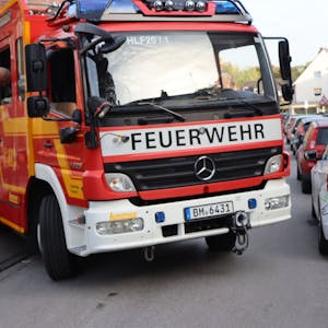 Auf dem Foto ist zu sehen, wie sich ein Feuerwehrauto an den am Straßenrand geparkten Pkw vorbeischiebt.
