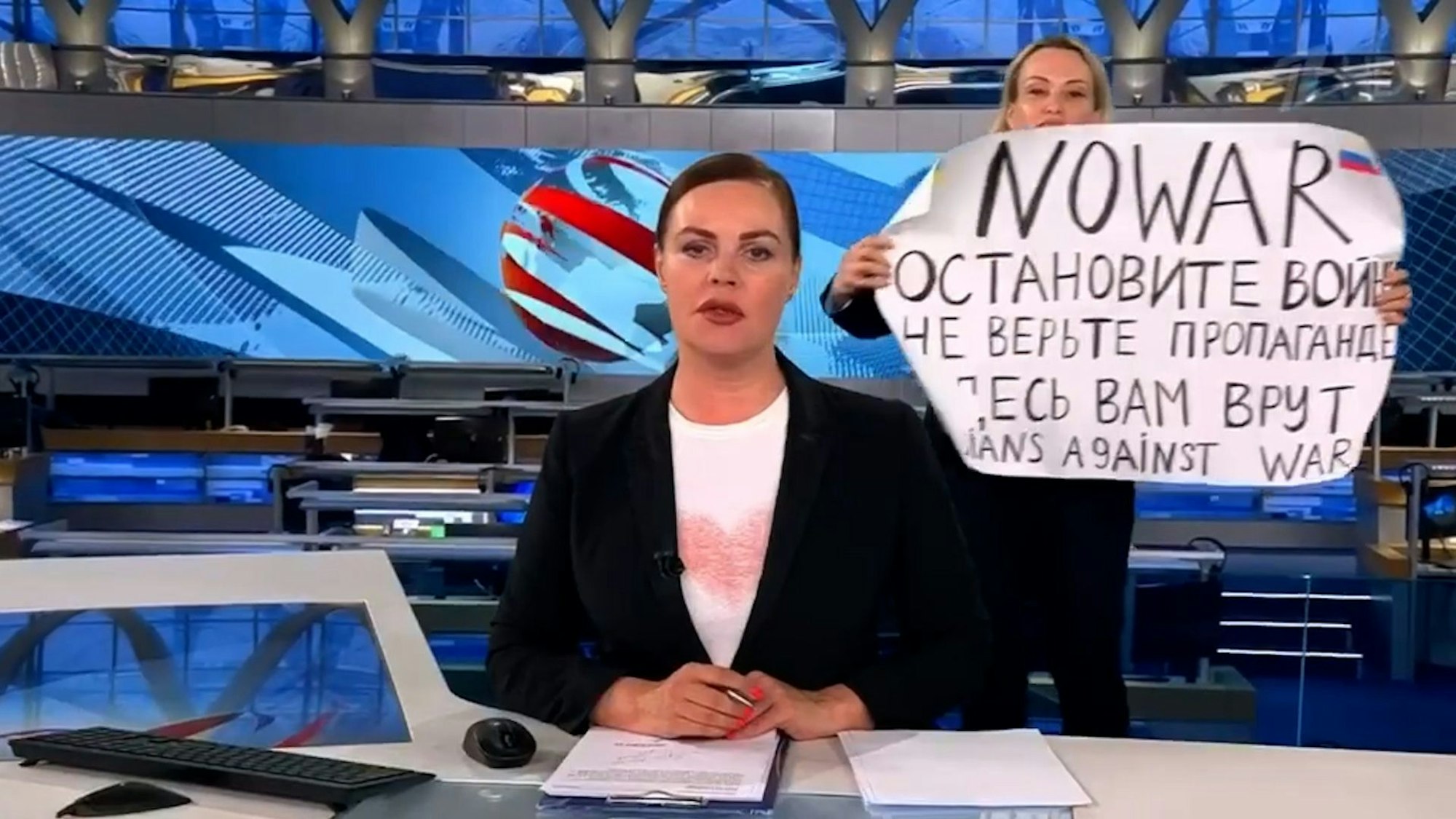 Der Screenshot aus der abendlichen Hauptnachrichtensendung des russischen Staatsfernsehen zeigt Redakteurin Marina Owsjannikowa (r) mit einem Protestplakat mit der Aufschrift„Stoppt den Krieg. Glaubt der Propaganda nicht. Hier werdet ihr belogen“ hinter der Nachrichtensprecherin Jekaterina Andrejewa.