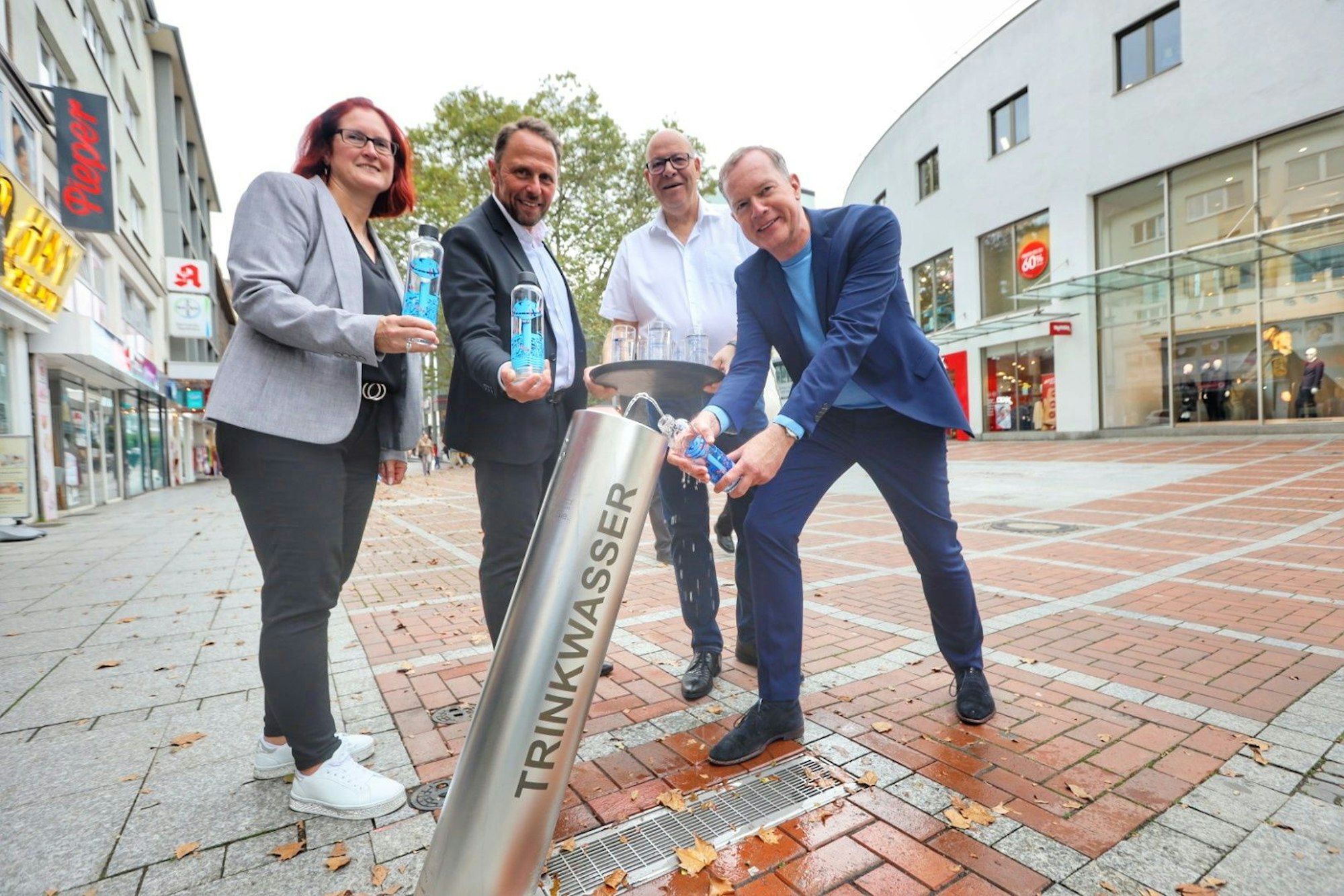 Bezirksbürgermeisterin Michaela Di Padova, Oberbürgermeister Uwe Richrath, Ralf Billstein, Projektleiter EVL und EVL-Geschäftsführer Thomas Eimermacher testen den neuen Trinkwasserbrunnen.
