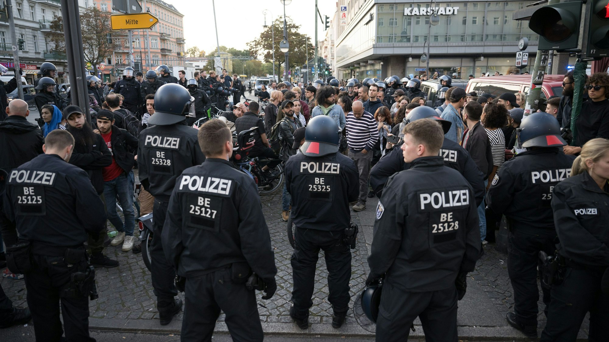 Polizeibeamte stehen in Berlin-Neukölln auf dem Hermannplatz vor einer Gruppe, aus der "Free Palestine"-Rufe kamen.