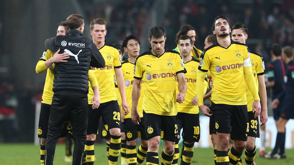 Spieler von Borussia Dortmund gehen vom Platz und werden vom damaligen Trainer Thomas Tuchel umarmt.