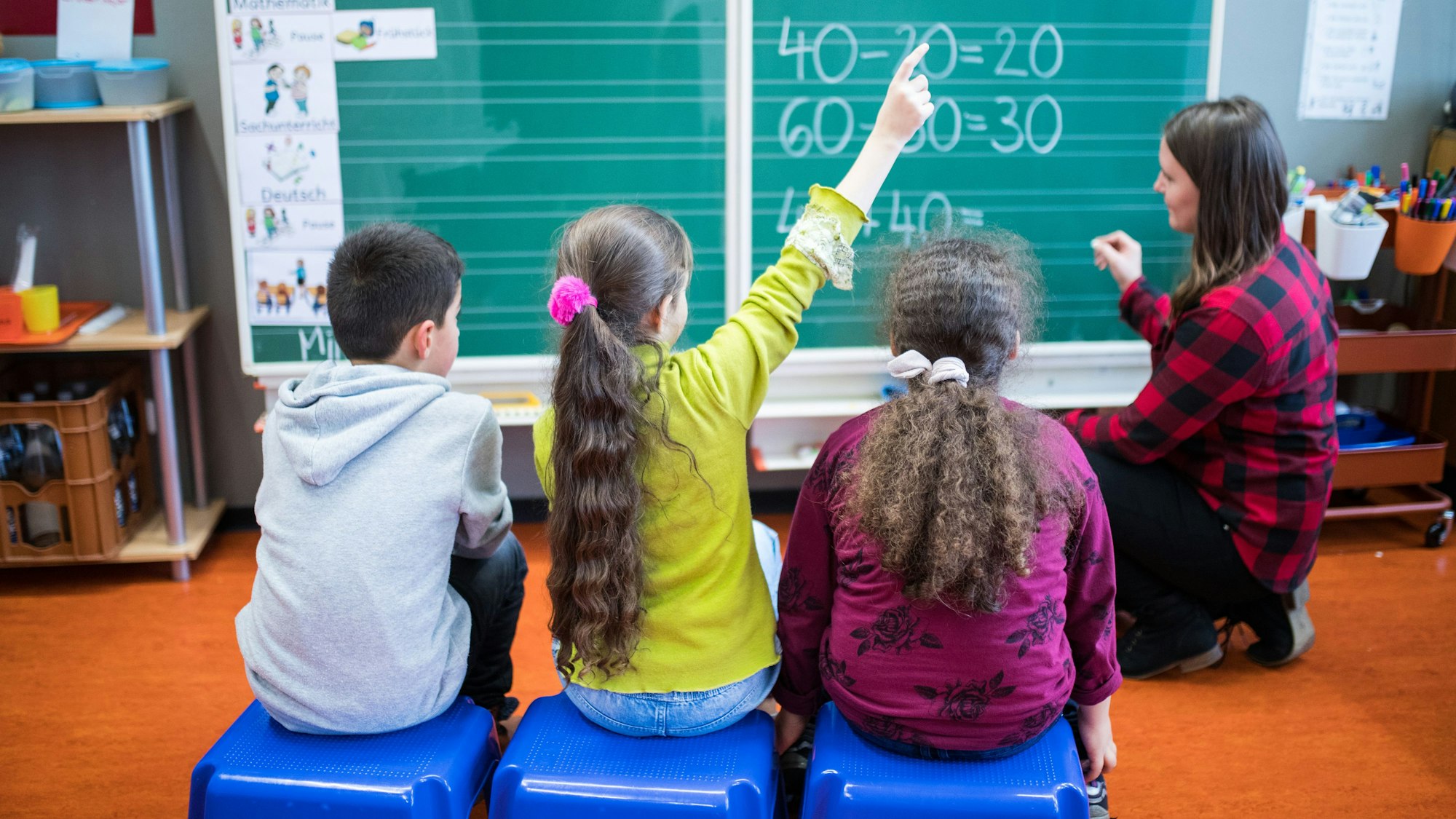 Schüler sitzen in einer Grundschule während einer Mathe-Übung vor der Tafel.