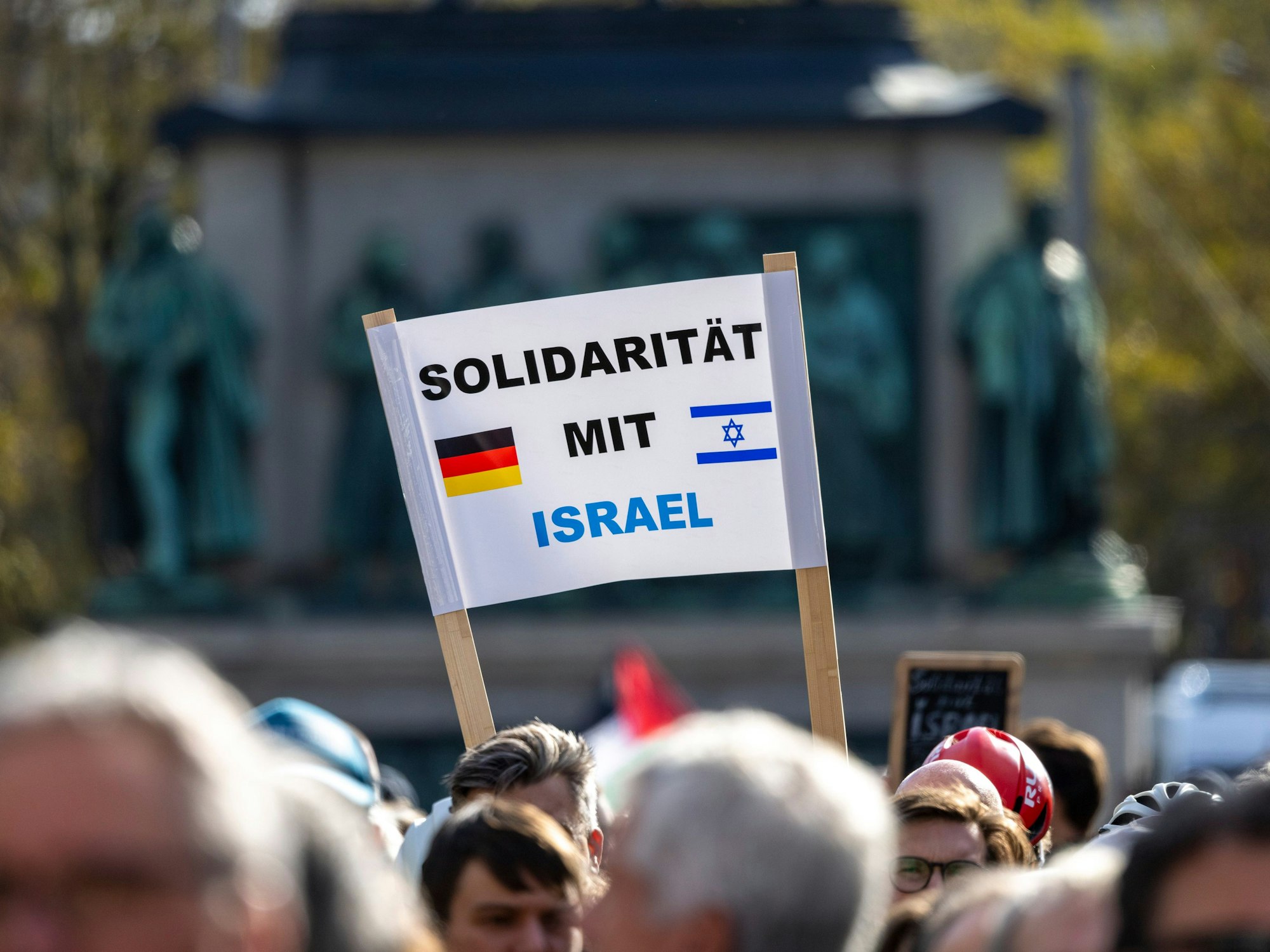 Ein Teilnehmer hält ein Plakat mit der Aufschrift: „Solidarität mit Israel“ in die Höhe.