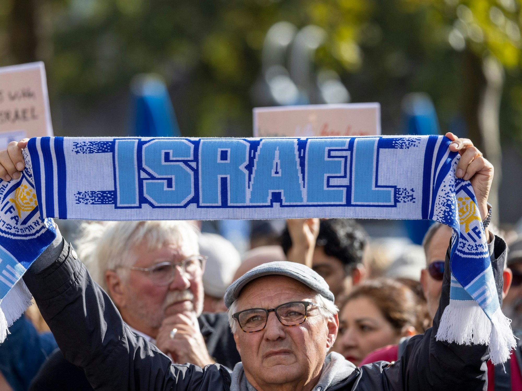 Ein Teilnehmer der Demo hält einen Schal mit der Aufschrift: „Israel“ in die Höhe.