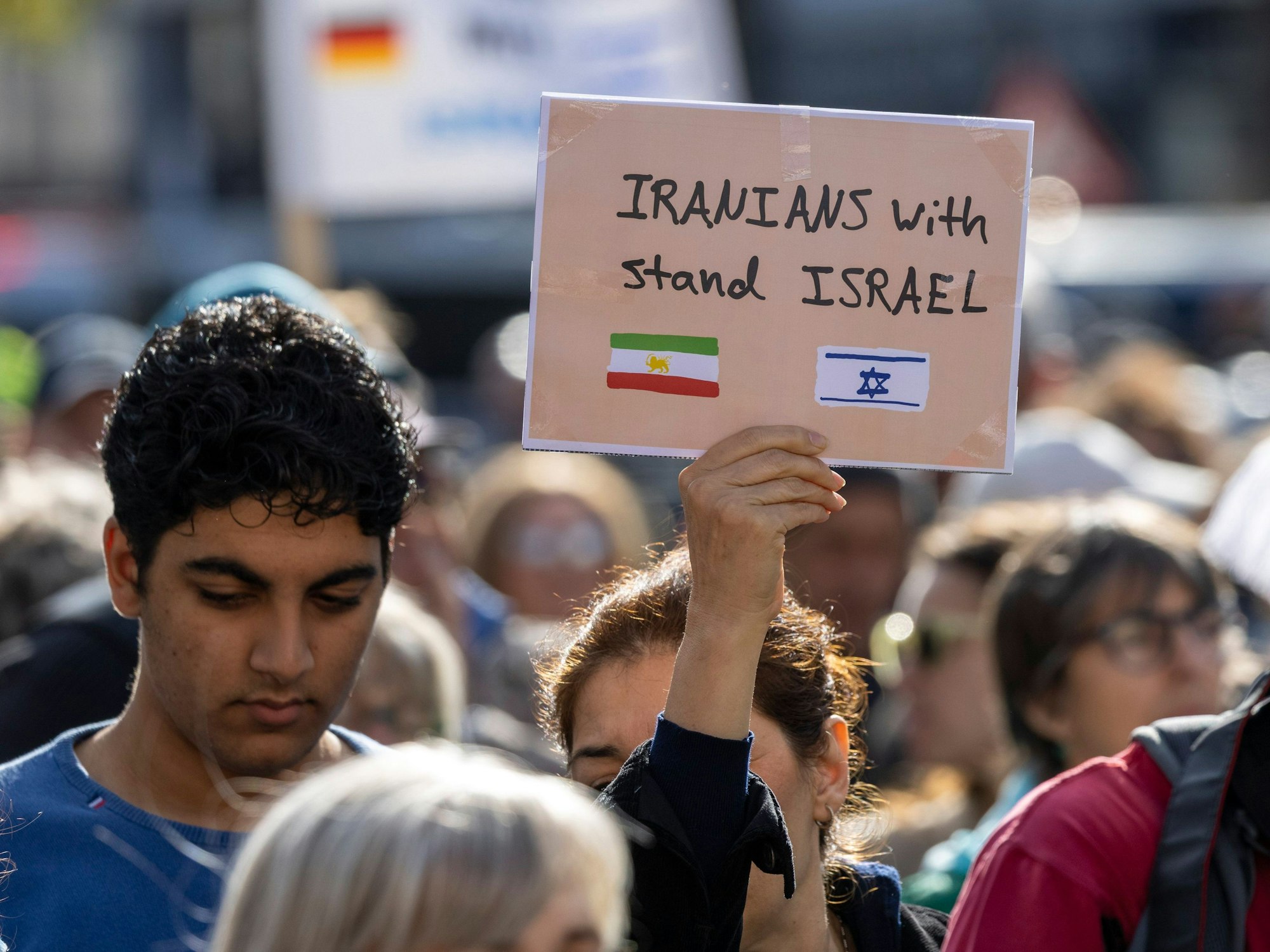 Eine Teilnehmerin mit einem Plakat mit der Aufschrift: „Iranians stand with Israe“l (Iraner stehen an der Seite von Israel).
