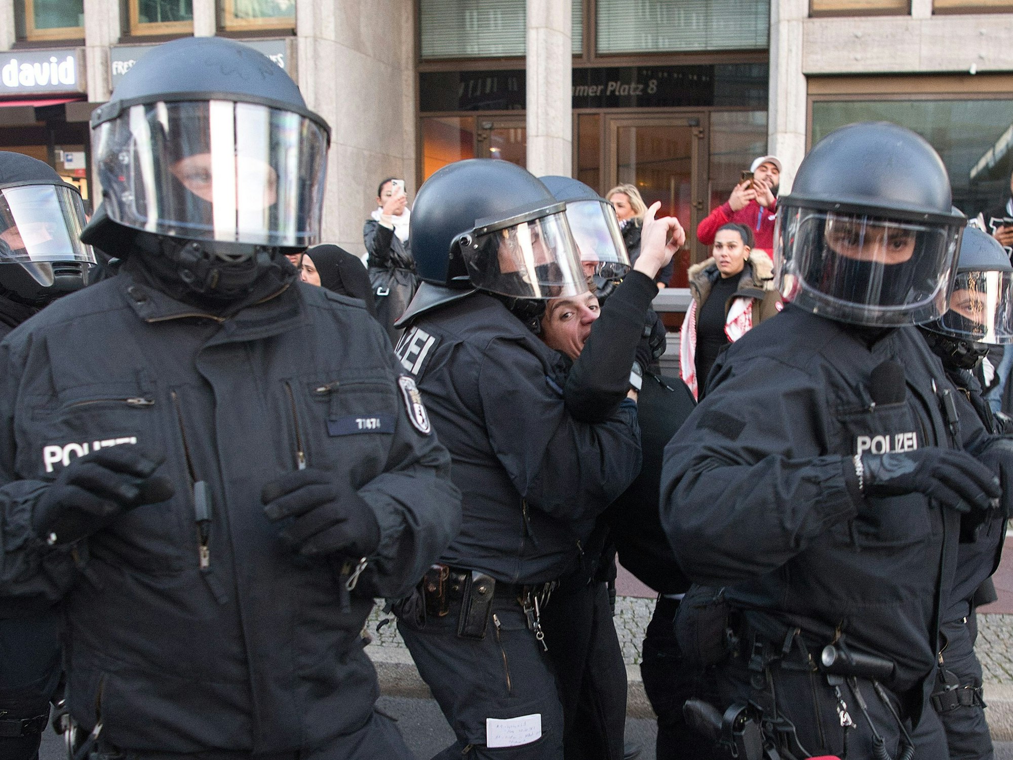 Polizisten sind bei einer verbotenen Pro-Palästina-Demonstration am Potsdamer Platz im Einsatz und nehmen eine Person fest.