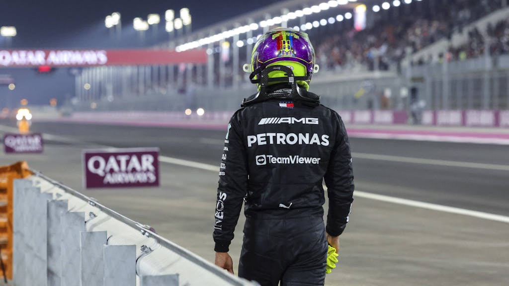 Lewis Hamilton geht beim Rennen der Formel 1 in Katar nach seinem Ausfall am Streckenrand entlang.