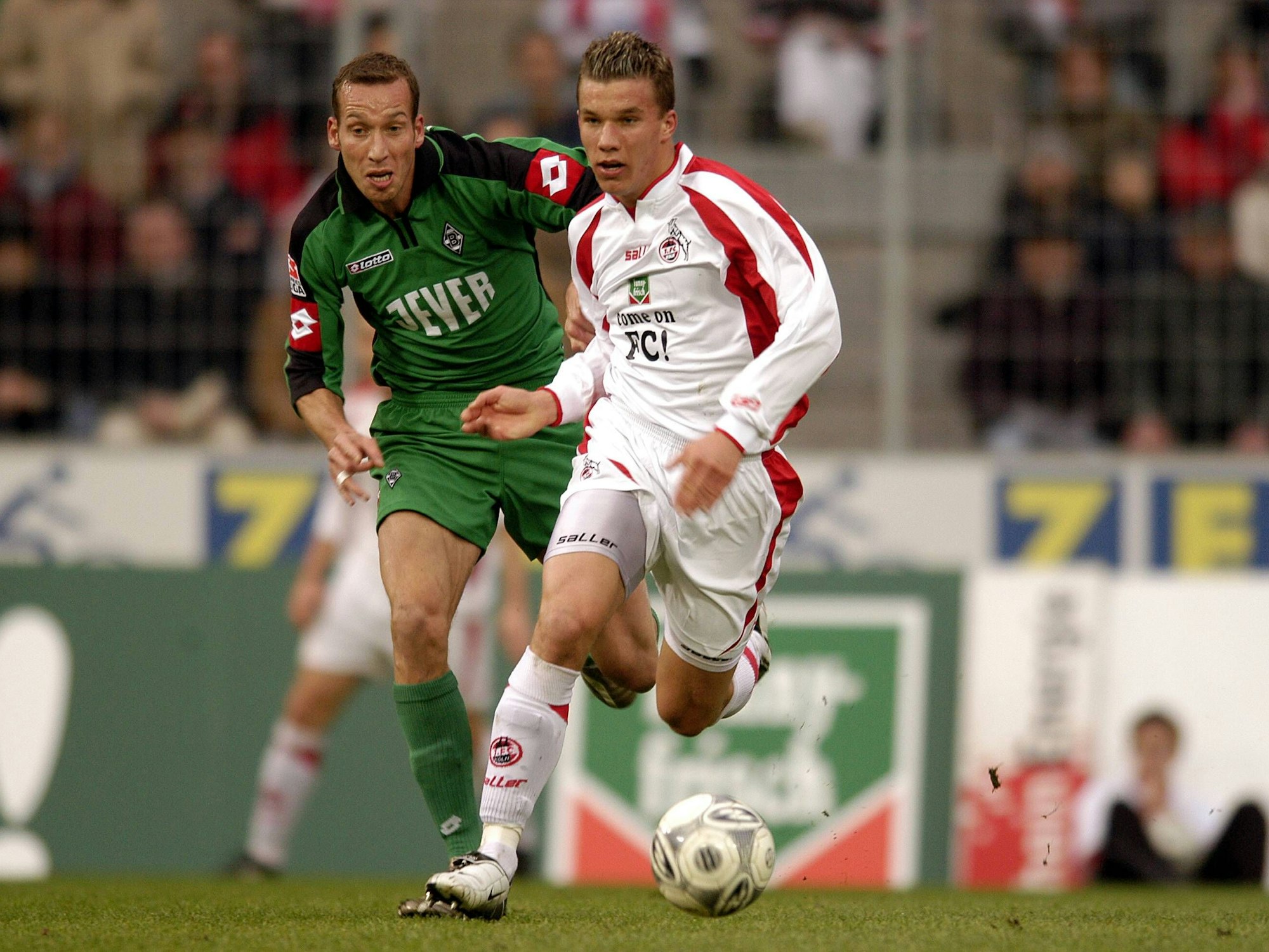 Lukas Podolski (r., 1. FC Köln) und Jeff Strasser (Borussia Mönchengladbach) auf dem Fußballfeld (2004).