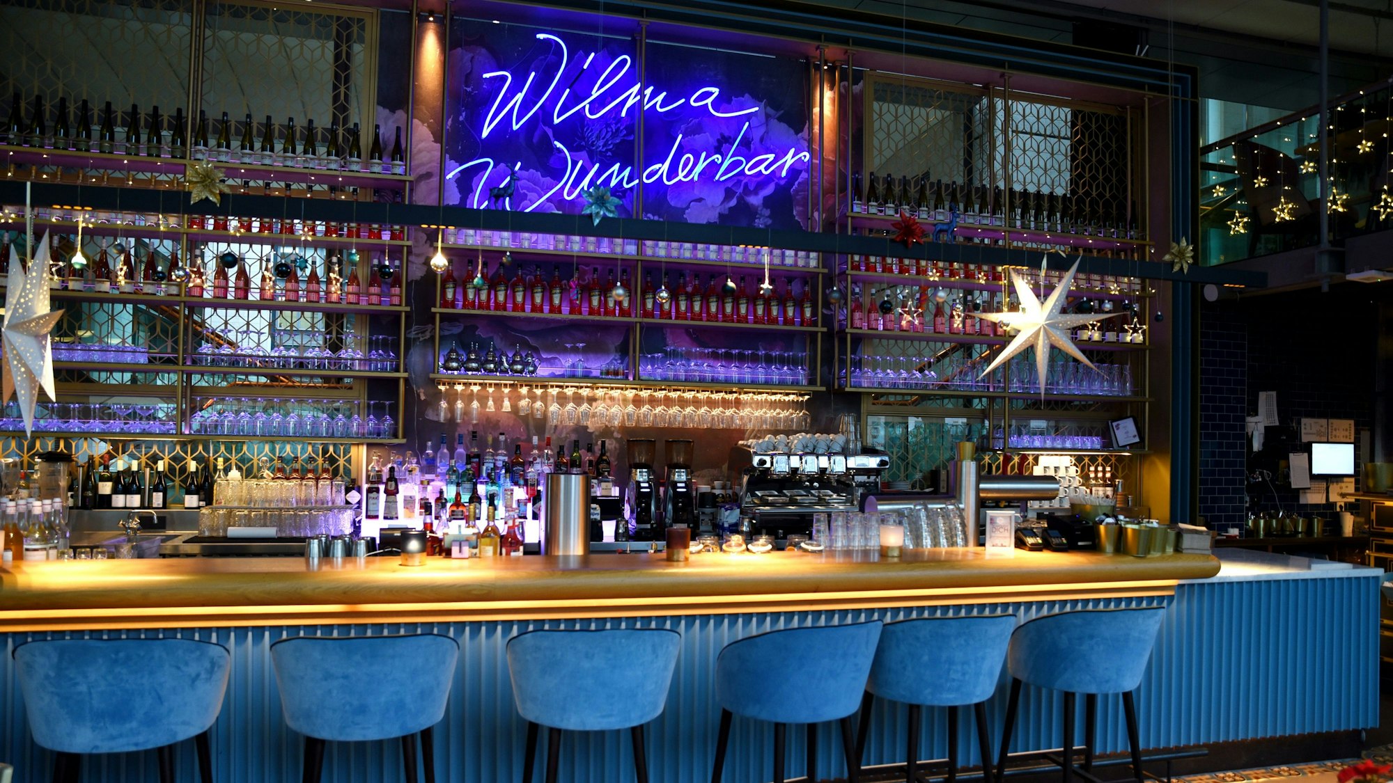 Das blaue Wilma Wunderbar - Schild leuchtet über der Bar.