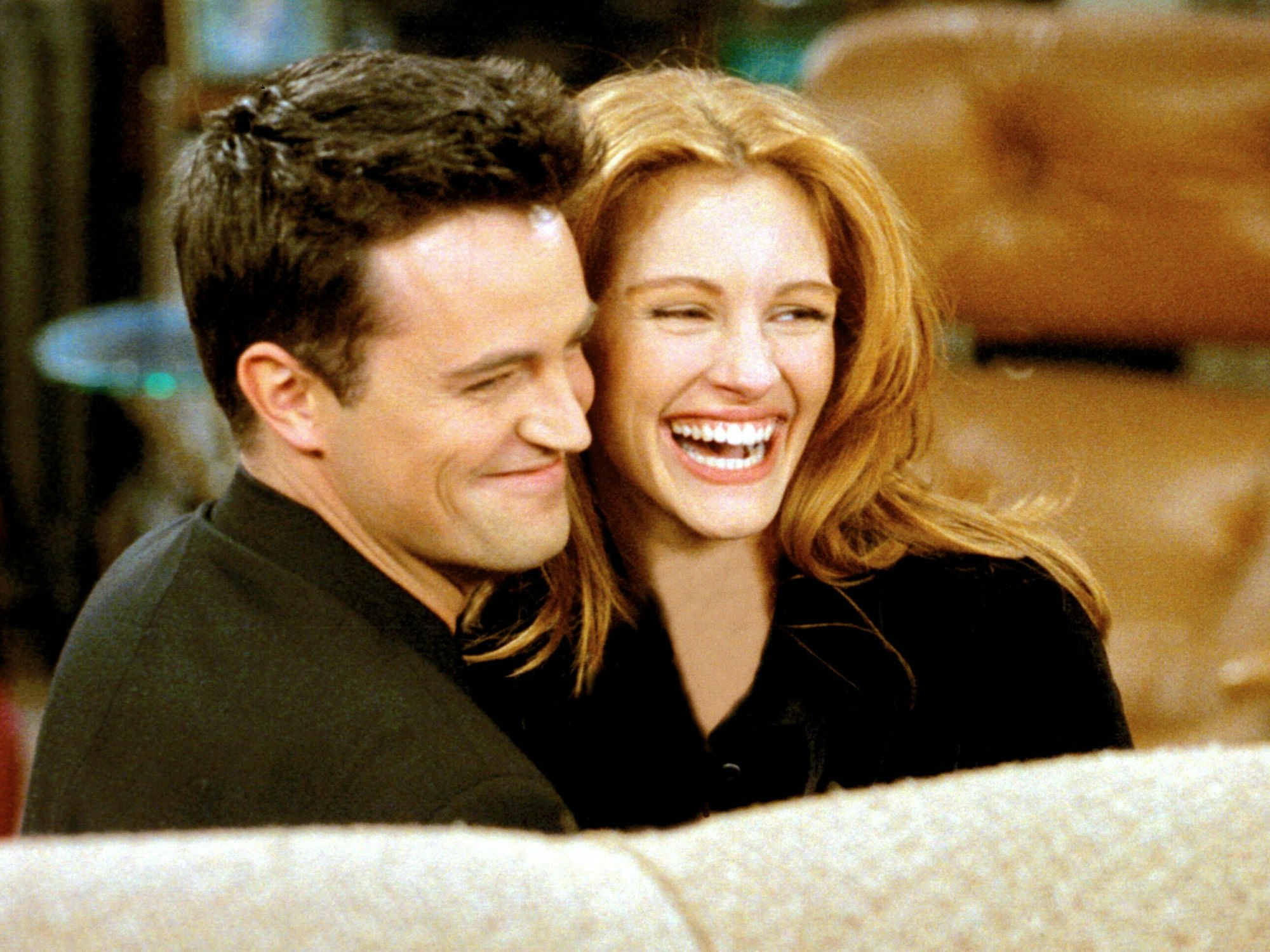 Matthew Perry und Julia Roberts lachen am Set von der Serie „Friends“ zusammen.