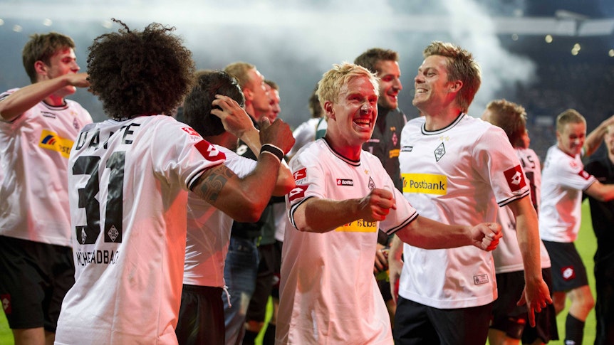 Spieler von Borussia Mönchengladbach jubeln mit den Fans nach dem Klassenerhalt in der Relegation.