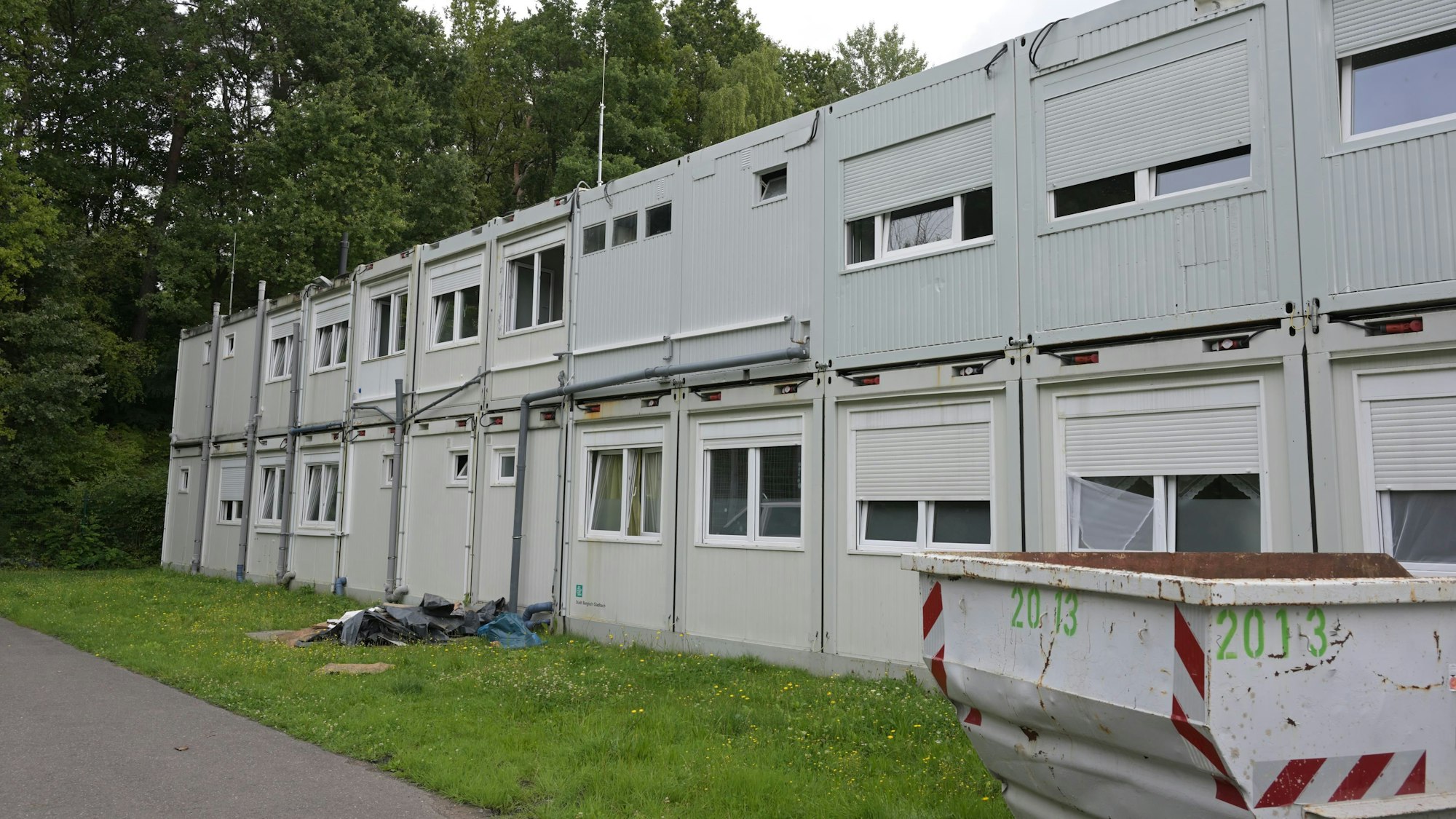 Umgeben von Grün, stehen Wohncontainer aufgereiht am Rande von Lückerath.