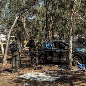 Israelische Soldaten untersuchen ein Auto auf einem Festivalgelände, bei dem die Hamas-Terroristen hunderte Menschen getötet und Geiseln genommen haben.