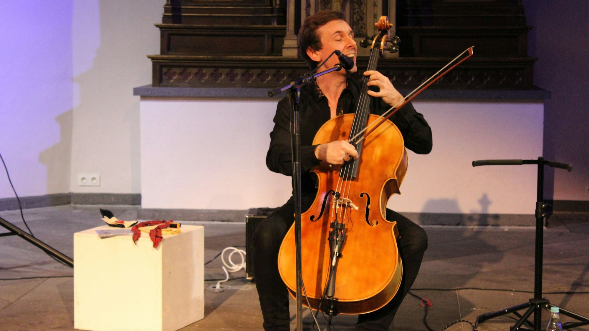 Ein Mann spielt Cello in einer Kirche.