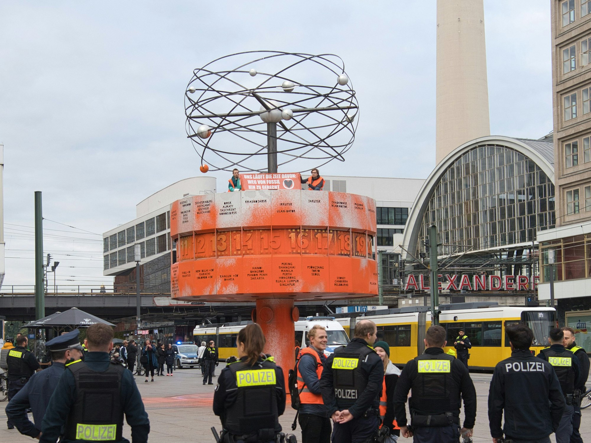 Aktivistinnen und Aktivisten der Gruppe „Letzte Generation“ haben die Weltzeituhr am Alexanderplatz in Berlin orange eingefärbt.