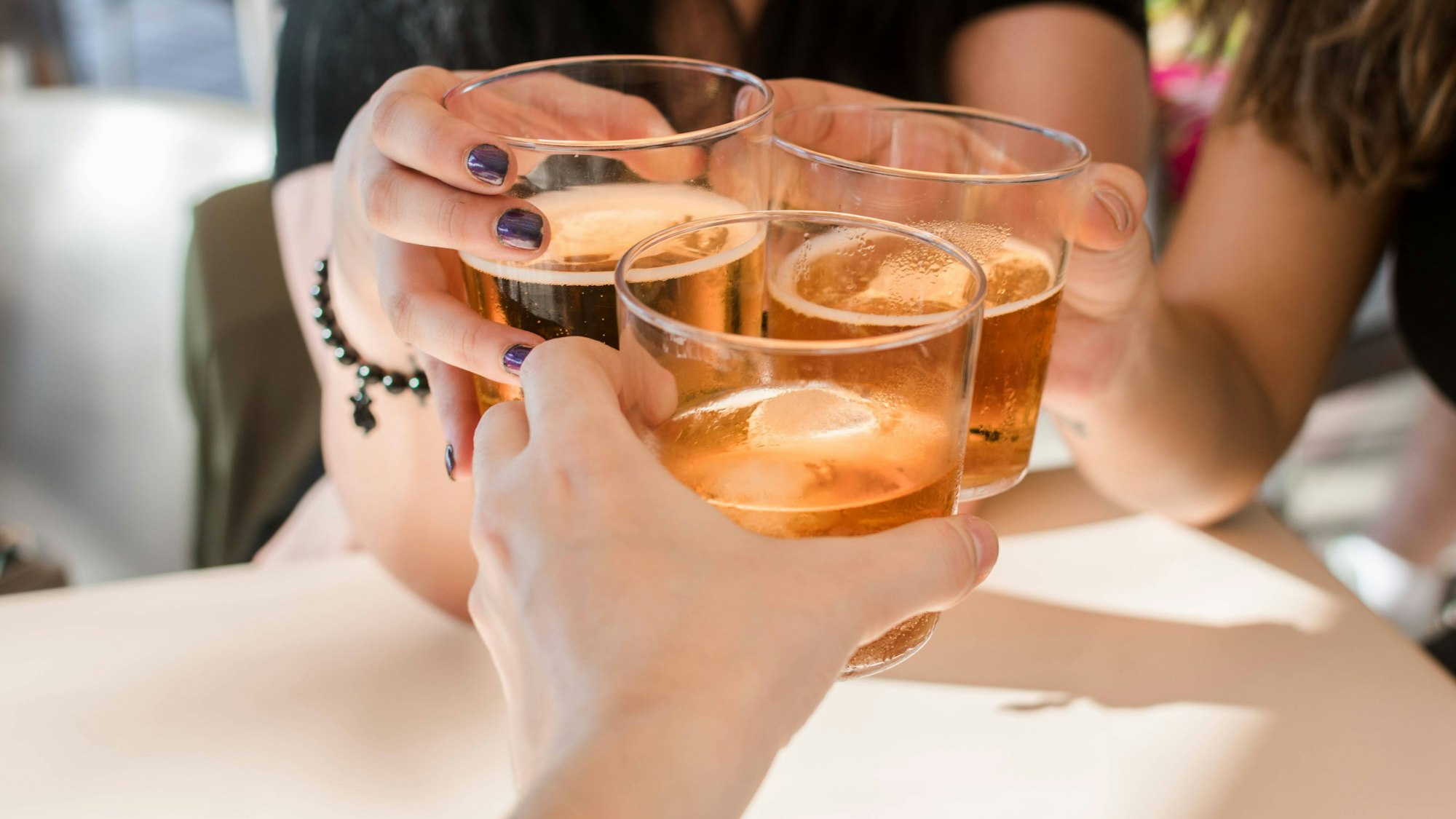 Personen stoßen mit alkoholischen Getränken an. Laut einer neuen Empfehlung der Deutschen Hauptstelle für Suchtfragen ist jeder Alkoholkonsum schädlich, auch in kleinen Mengen. (Symbolbild)