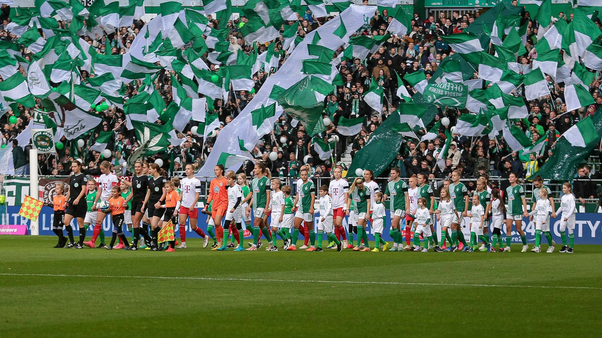 Die Mannschaften von Werder Bremen und dem 1. FC Köln laufen beim Spiel der Frauen-Bundesliga aufs Feld.
