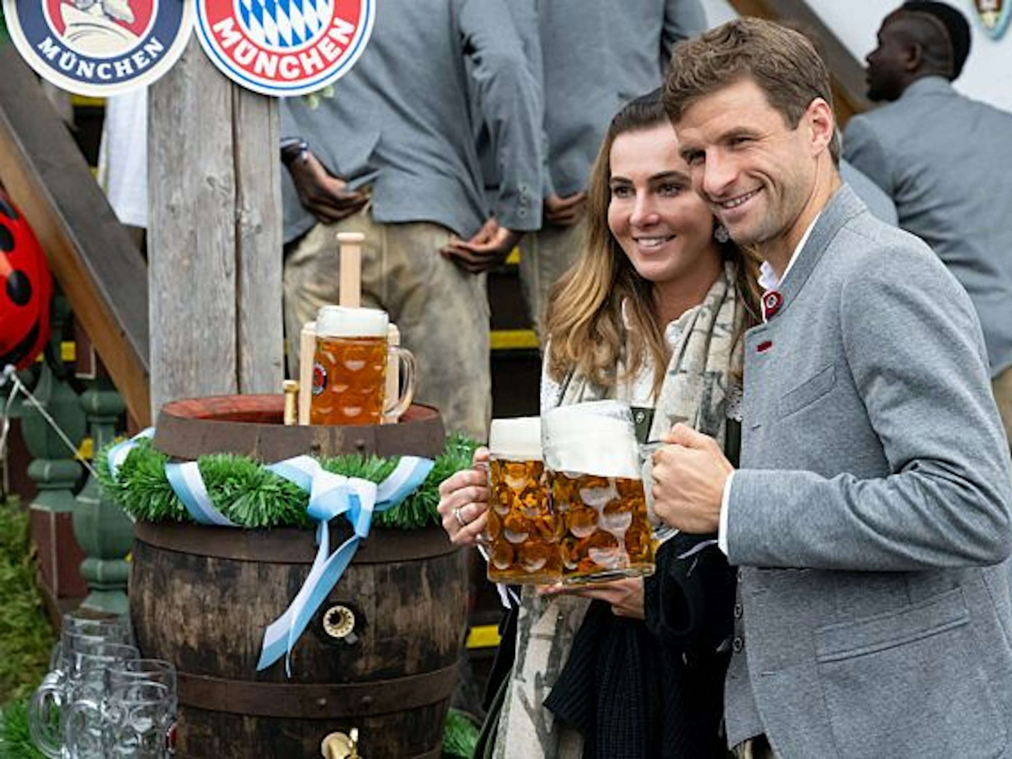 Thomas Müller vom FC Bayern München und seine Frau Lisa kommen in das Käferzelt auf dem Oktoberfest auf der Theresienwiese. Beide halten eine Maß Bier in der Hand und stoßen an.