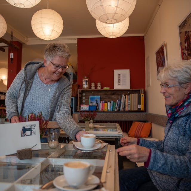 Monika Geißler serviert im Fair-Café in Zülpich einer Besucherin eine Tasse Kaffee.