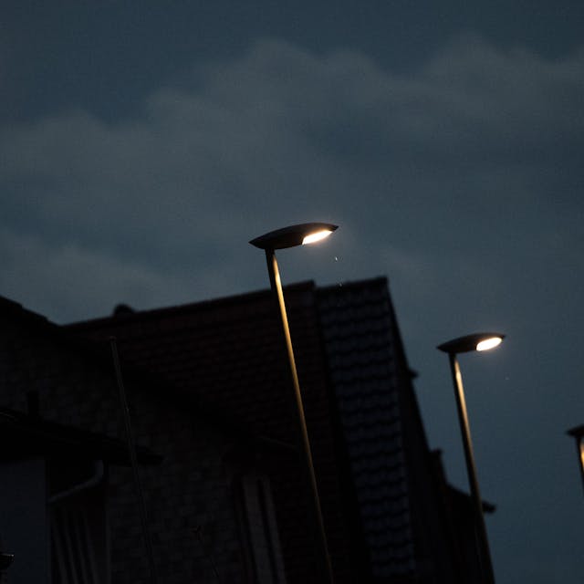 Mehrere LED-Straßenlampen leuchten vor dunklem Nachthimmel.