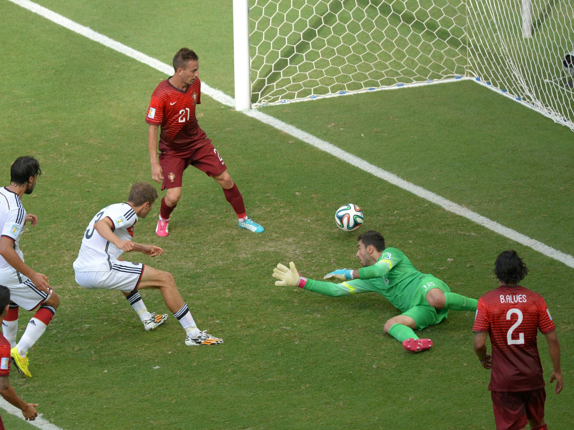 Im Fallen schießt Müller aus etwa zwei Metern den Ball in das portugiesische Tor. Torhüter und Verteidiger schauen dem Ball hinterher.