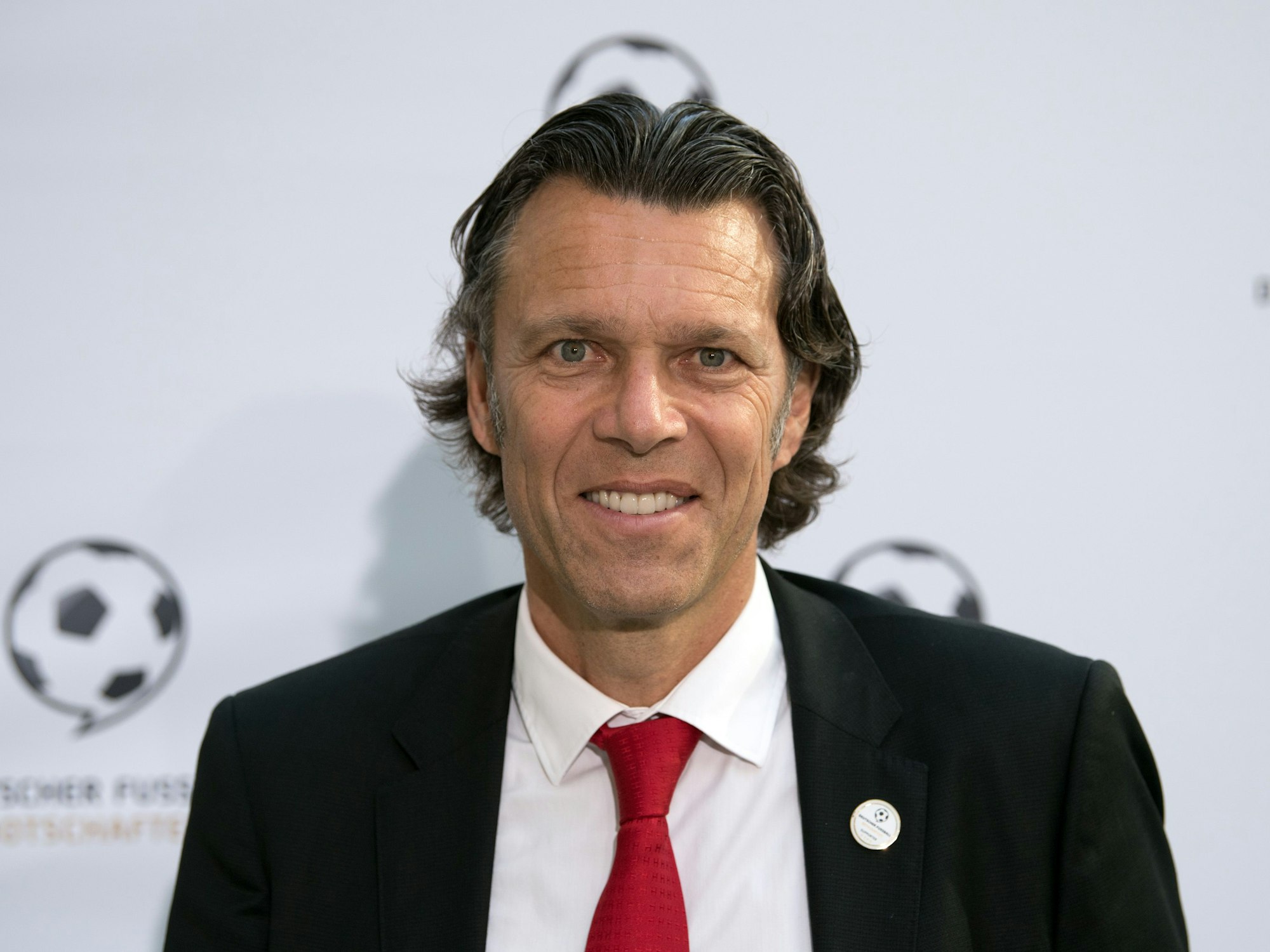 Urs Meier, früherer Schweizer Fußballschiedsrichter, lächelt bei einer Veranstaltung in die Kamera.