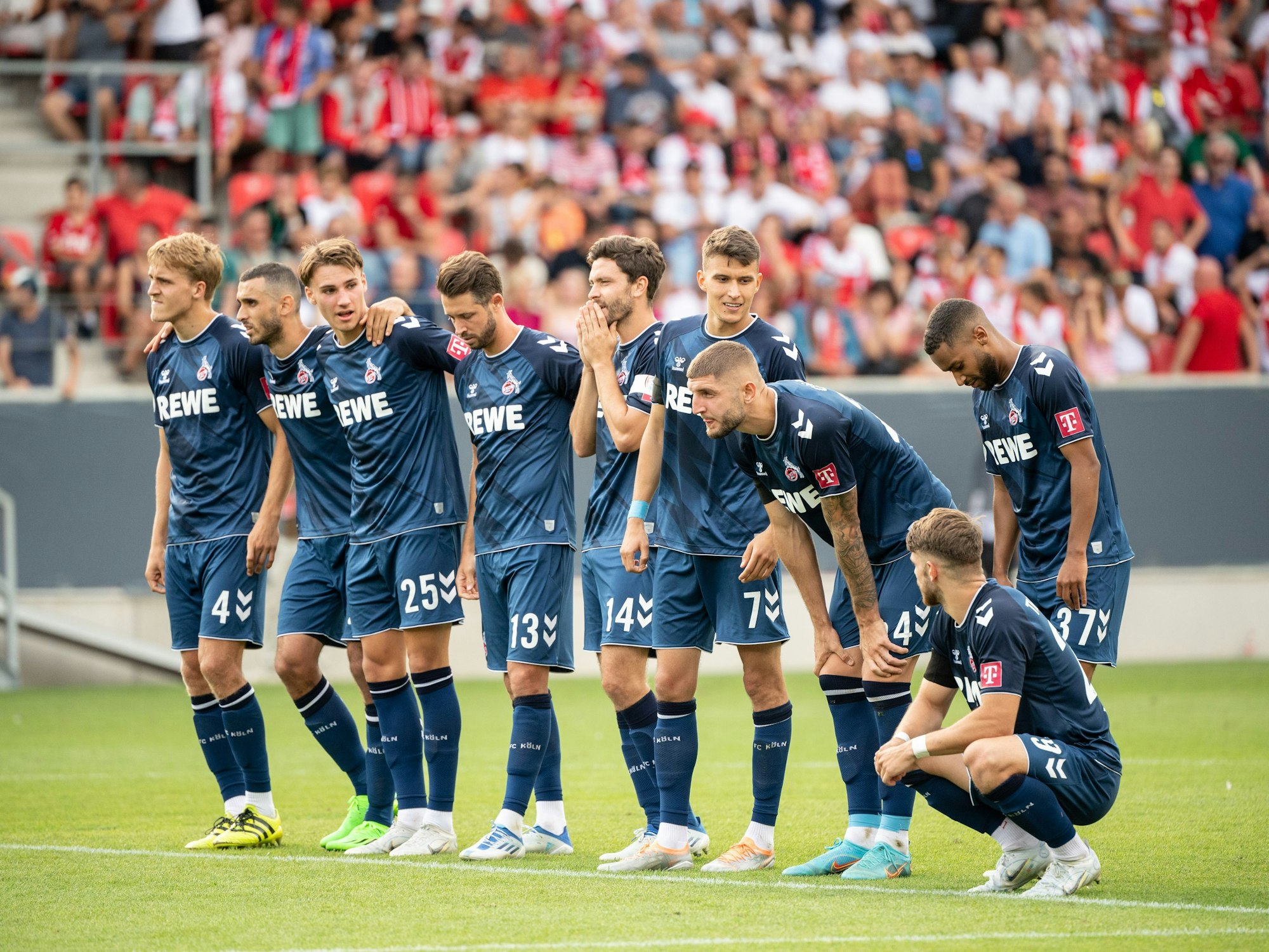 Die Spieler vom 1. FC Köln verfolgen das Elfmeterschießen und wirken enttäuscht.