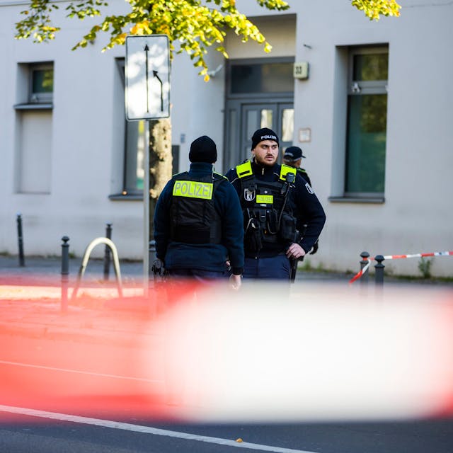 Polizeikräfte stehen vor der jüdischen Gemeinde Kahal Adass Jisroel in der Brunnenstraße in Berlin-Mitte. Auf das Haus mit jüdischen Einrichtungen hat es in der Nacht zu Mittwoch (18. Oktober) einen Brandanschlag gegeben.