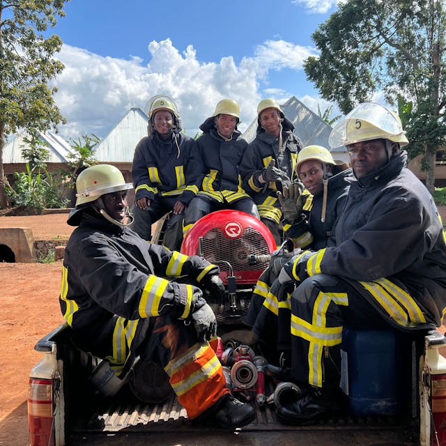 Foto von sechs Feuerwehrmännern mit Gerätschaften auf der Ladefläche eines Pick-ups.&nbsp;