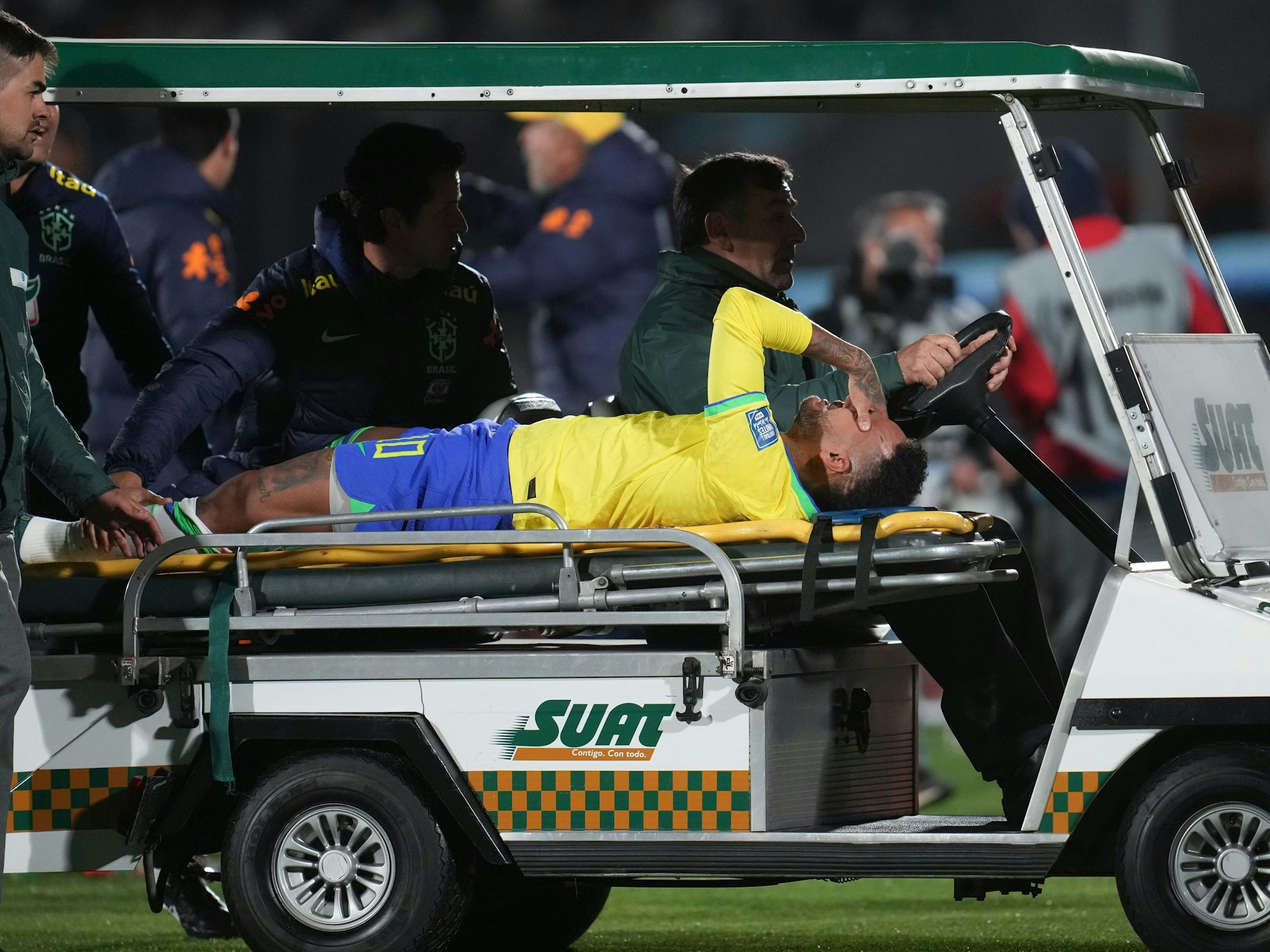 Brasiliens Neymar liegt auf der Trage und wird von einem Fahrzeug vomSpielfeld gefahren.