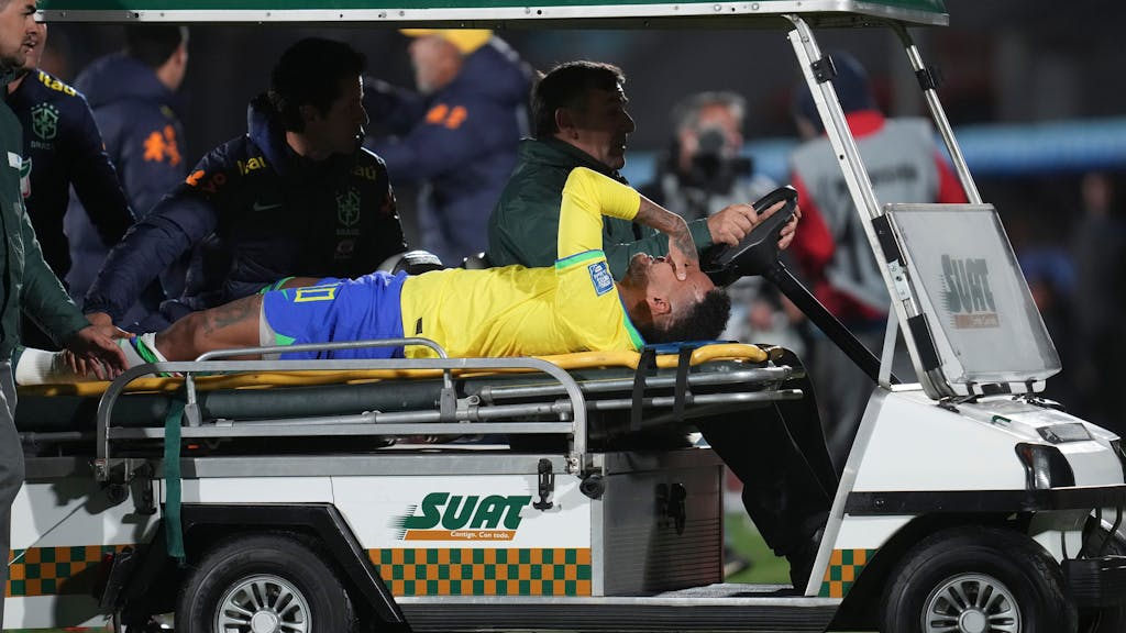 Brasiliens Neymar liegt auf der Trage und wird von einem Fahrzeug vom&nbsp;Spielfeld gefahren.
