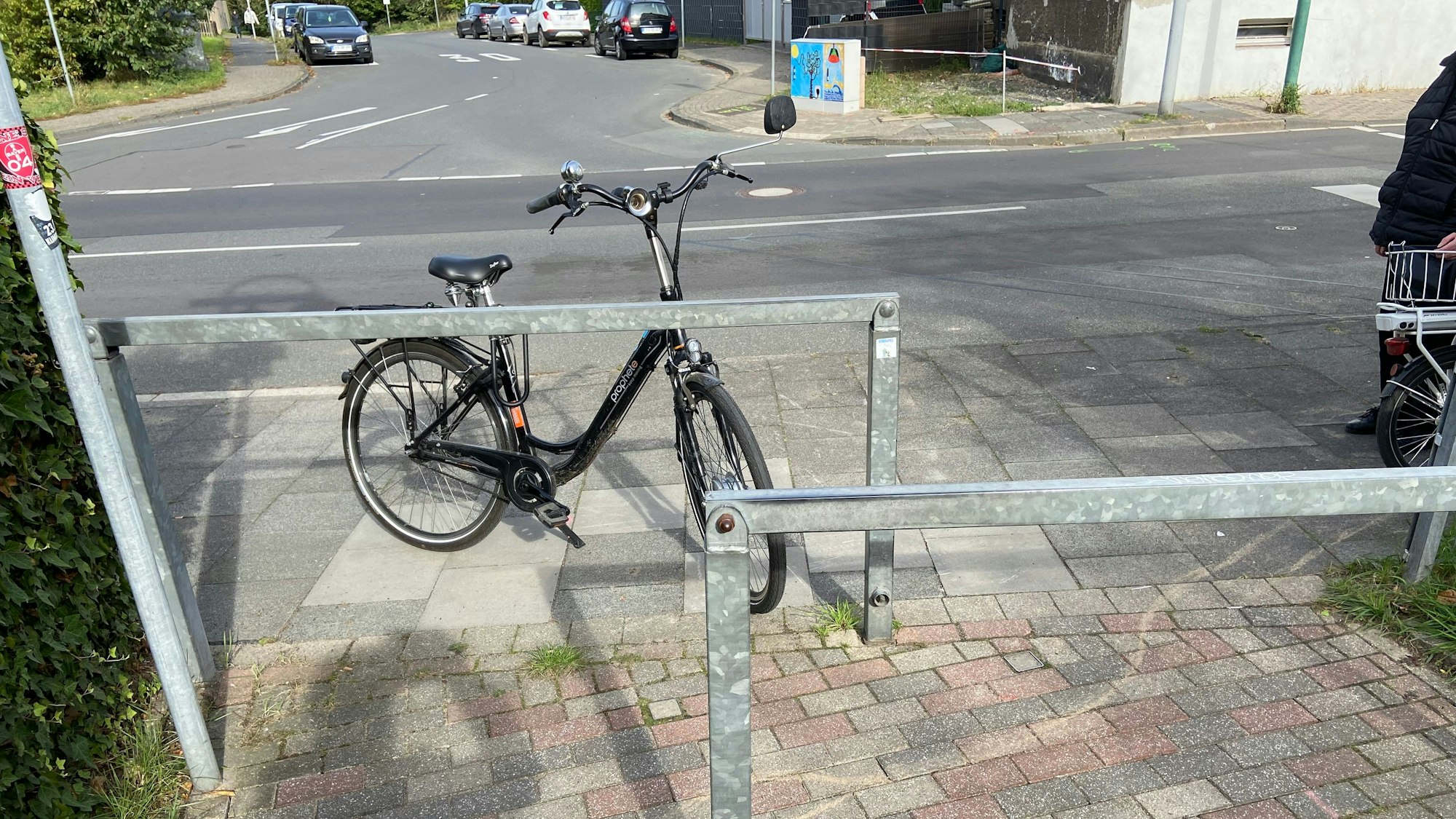 Ein Fahrrad steht an den Absperrgittern auf Höhe Am Hagelkreuz auf der Lützenkirchener Sraße.