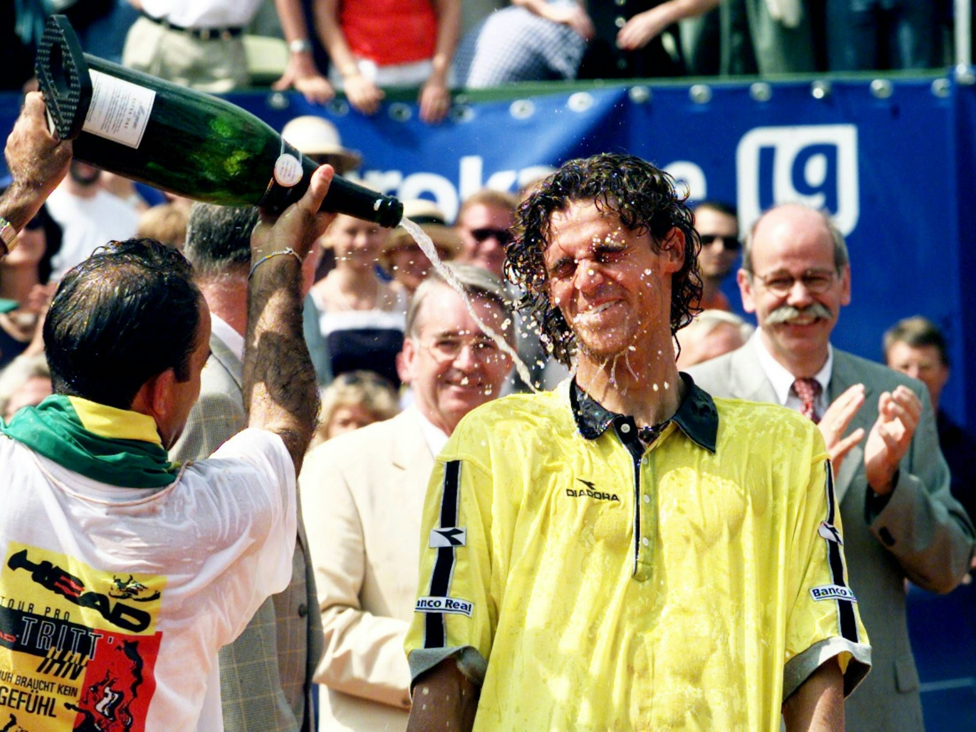 Gustvao Kuerten wird nach seinem Turniersieg in Stuttgart von seinem Trainer mit Champagner vollgespritzt.