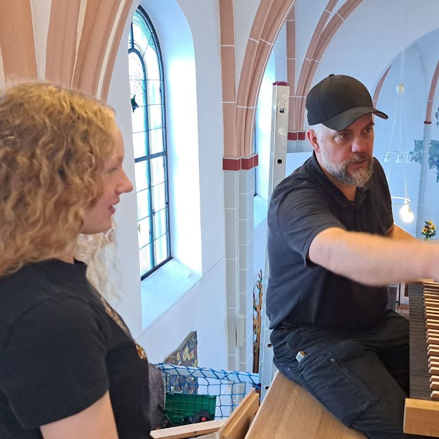 Das Bild zeigt Orgelbauer Martin Hiltmann und die Schülerin Fenja vor der Entdeckerorgel