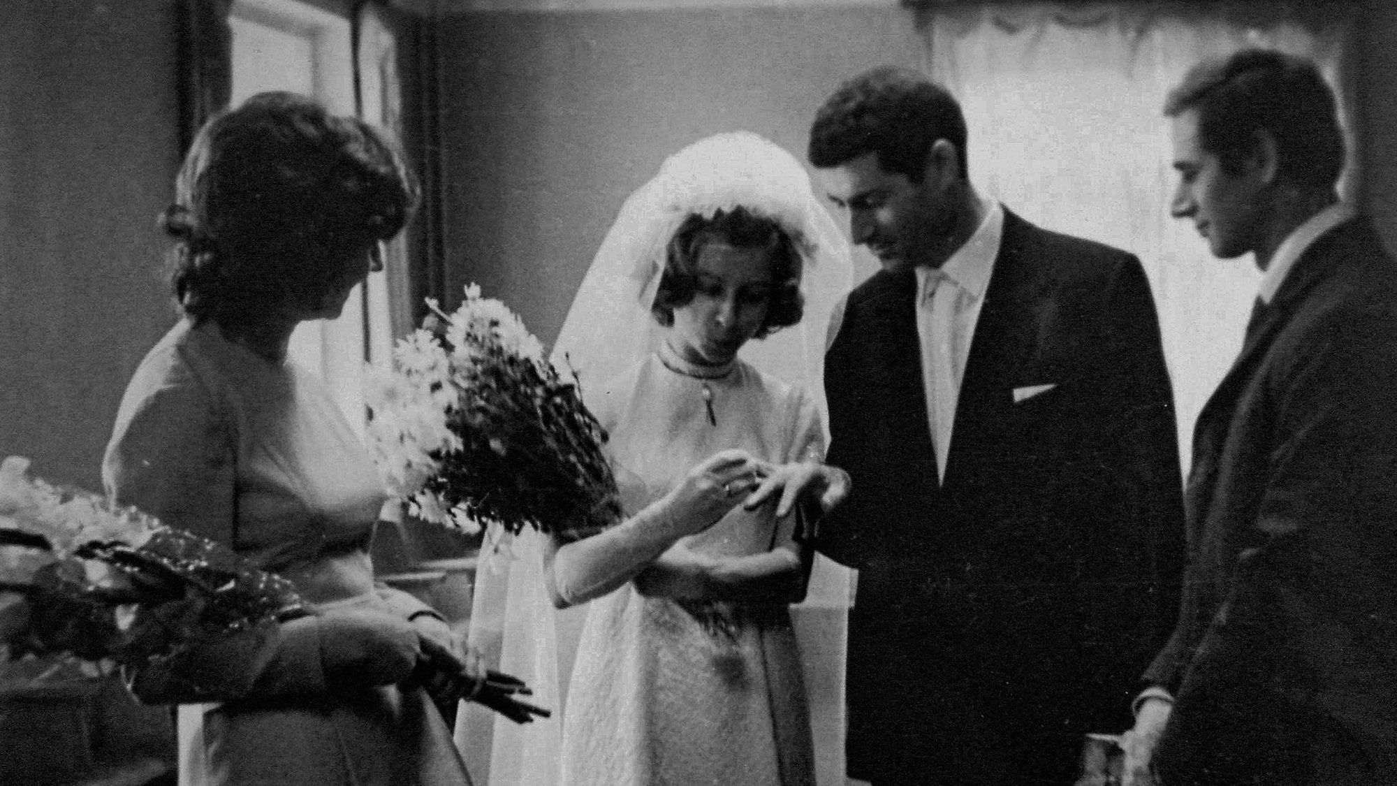 Ein Mann steckt seiner Braut den Ehering an.