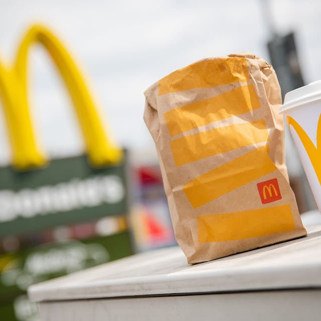 Eine McDonald's To-Go-Tüte und ein To-Go-Becher stehen vor einer Tübinger McDonald's-Filiale.&nbsp;