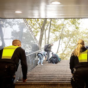 Zwei Mitarbeitende des Ordnungsamtes gehen die Treppen an der Neumarkt-Unterführung hoch, dort sitzen Drogenabhängige.