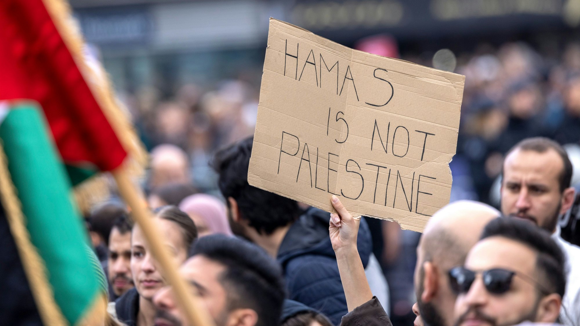 Ein Teilnehmer der Kundgebung hält ein Schild mit der Aufschrift „Hamas is not Palestine“ (Hamas ist nicht Palästina) hoch.