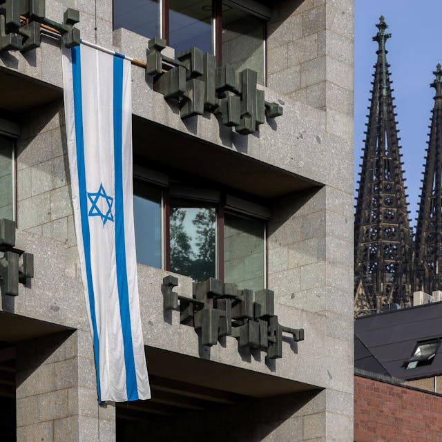 Zu sehen ist eine israelische Flagge an der Fassade des Kölner Rathauses.