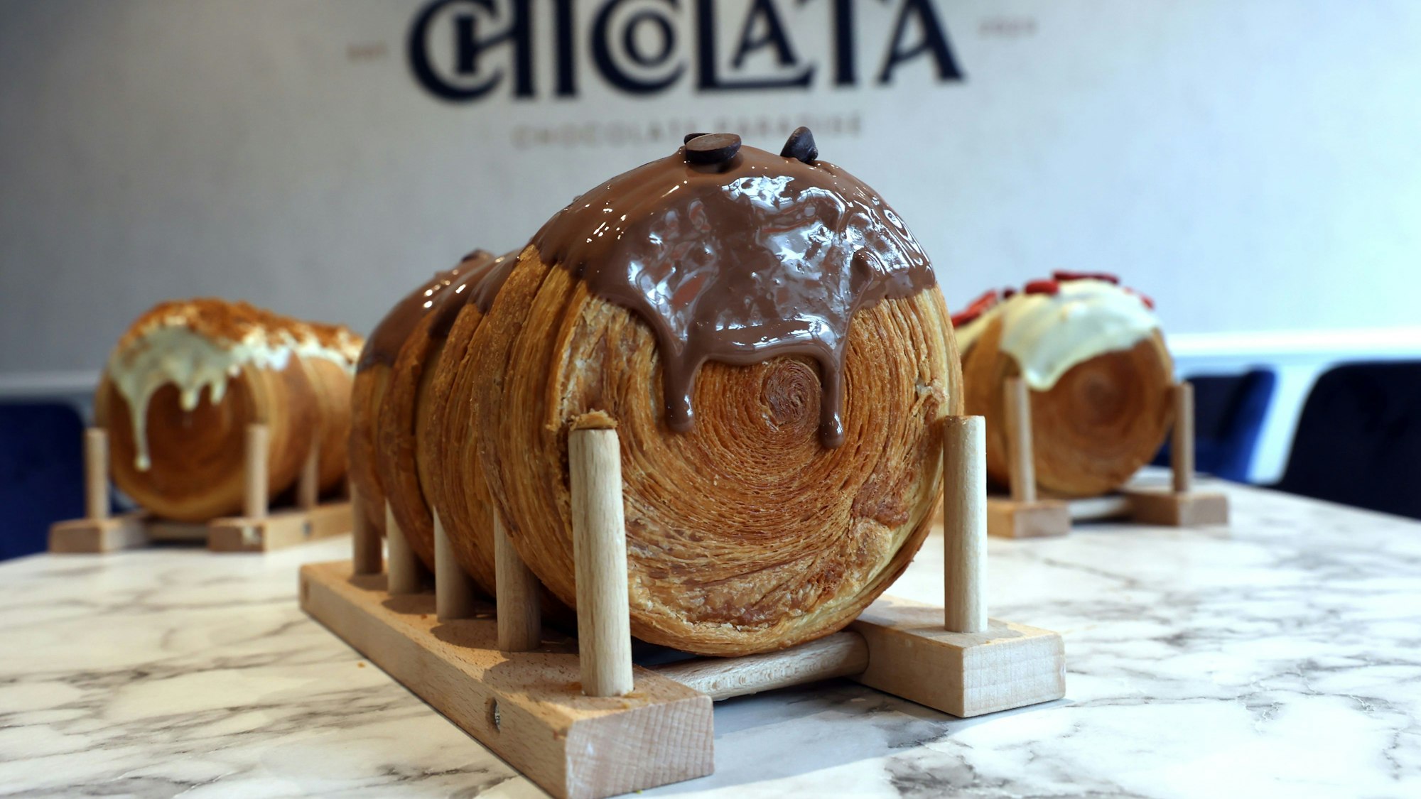 Das Foto zeigt mehrere Croissant Rolls, im Vordergrund ist eine mit Schokoladenguss zu sehen.
