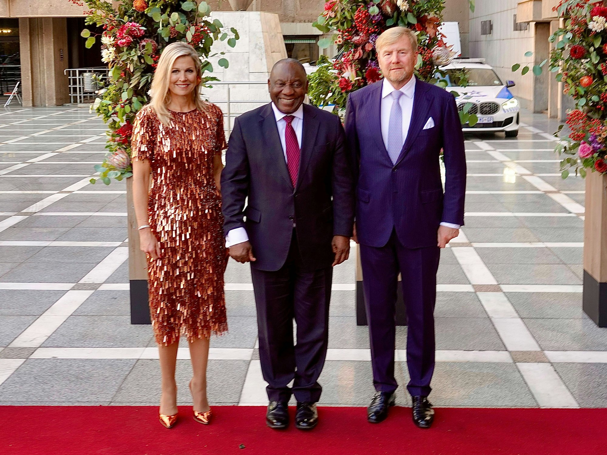 Königin Maxima (l) und König Willem-Alexander (r) mit Südafrikas Präsident Cyril Ramaphosa vor der Theatervorstellung „Unbreakable“, die von Lloyds Company und niederländischen Musikern in Pretoria aufgeführt wird.