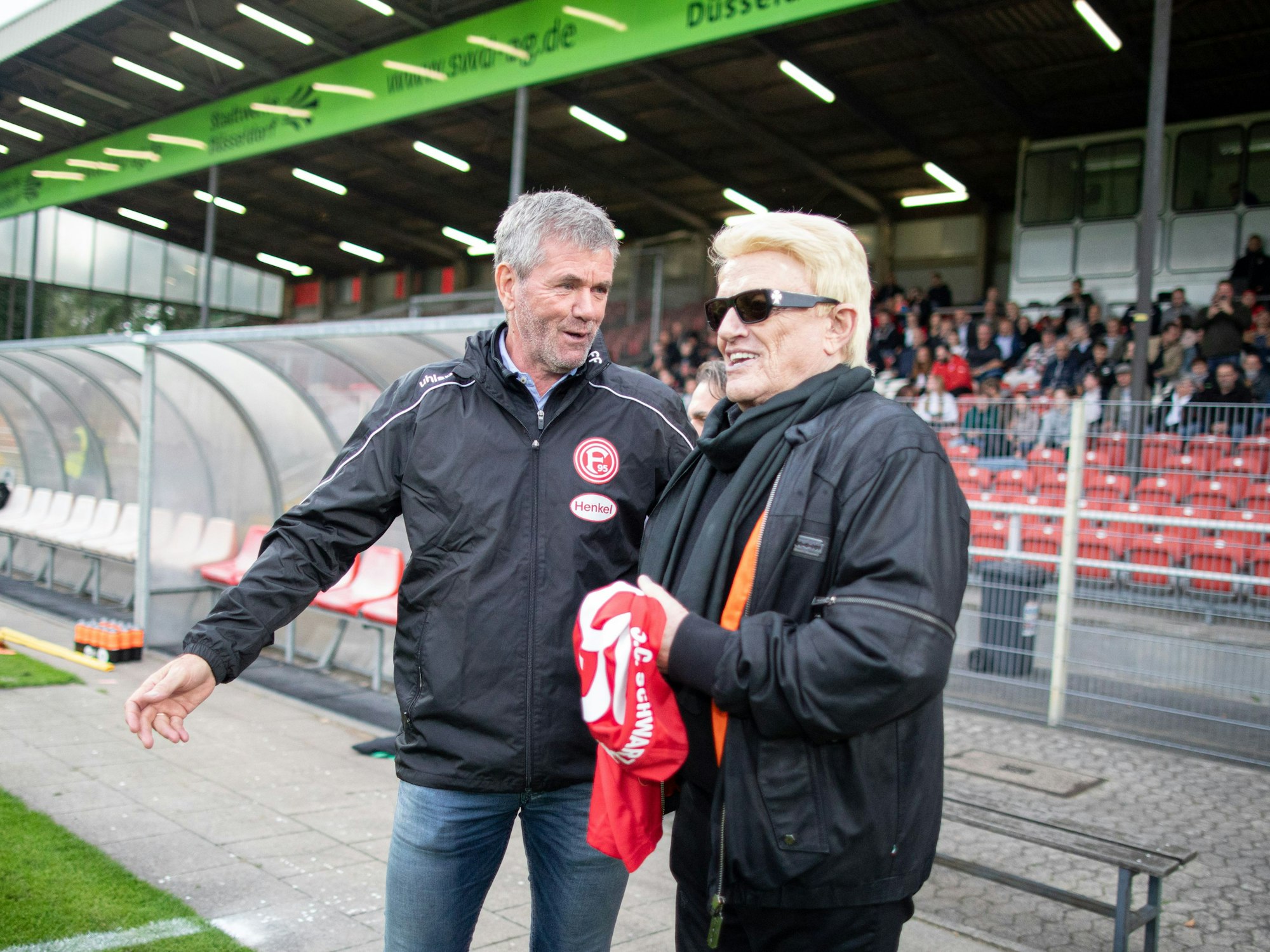 Heino (r), Musiker und Ehrenmitglied des Fußballvereins Schwarz Weiß 06 Düsseldorf, steht vor dem Anstoß für ein Benefizspiel auf dem Spielfeld neben Fortuna-Trainer Friedhelm Funkel.