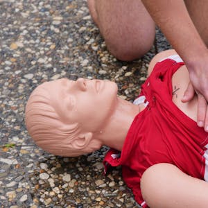 Eine Person übt die Herzdruckmassage an einer Erste-Hilfe-Puppe.
