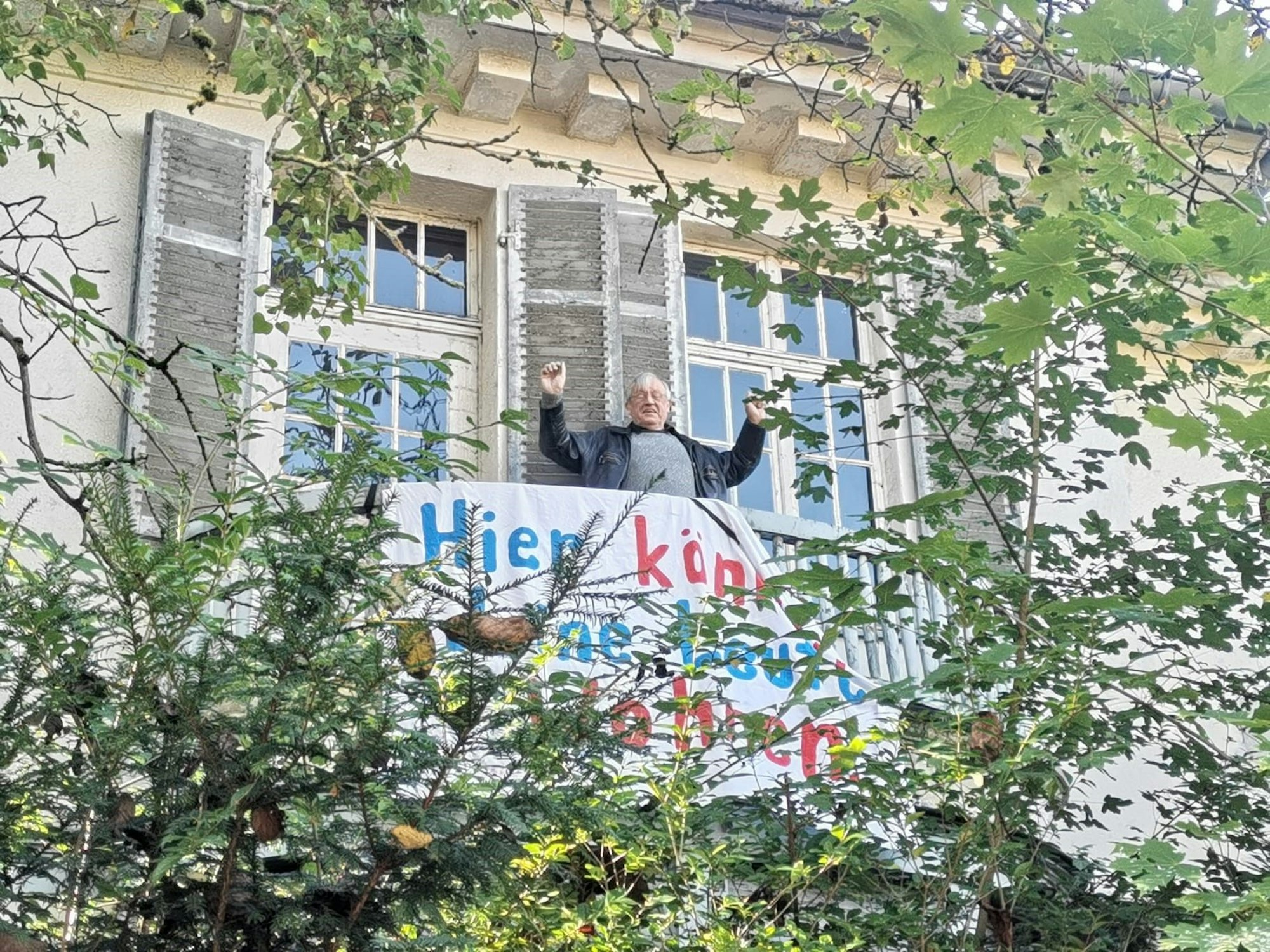 Ein Mann steht auf eine Balkon.
